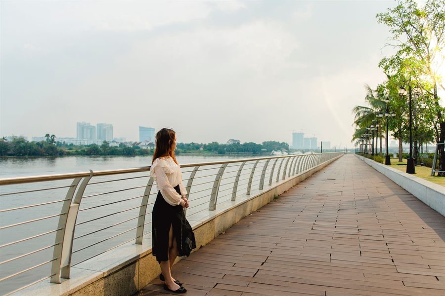 Woman alone on a riverside promenade