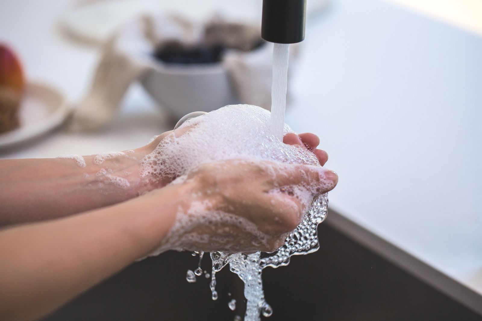 Hands lathered with soap under running water