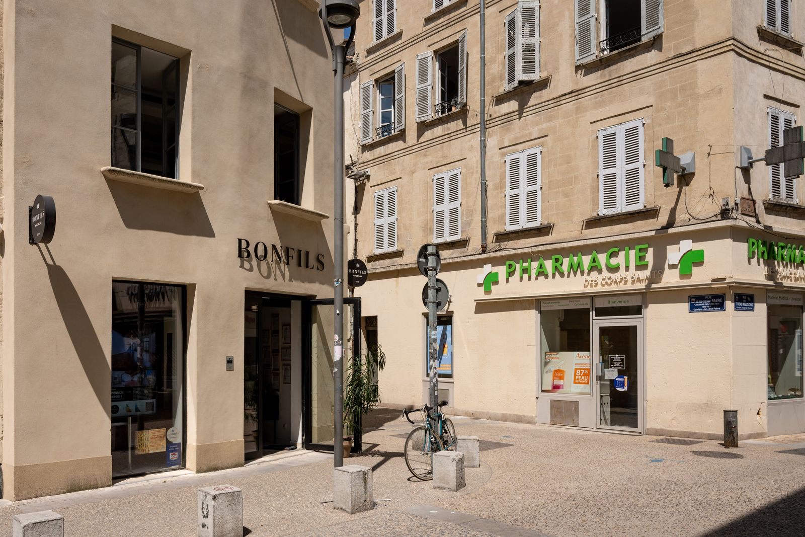 Pharmacy with a green cross on a sunny street in Avignon, France