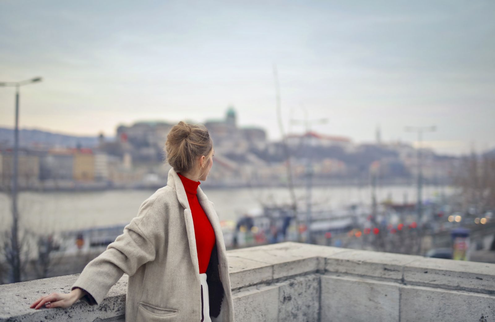 Woman traveling alone looking across the Danube toward Buda Castle in Budapest